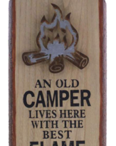 Wooden sign with text "an old camper lives here with the best flame of his life" below a log fire