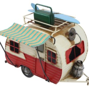 A white and red miniature camper with an awning, luggage, and a surfboard on the roof
