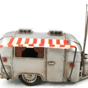 A one foot long miniature camper made of metal and painted to look old and retro